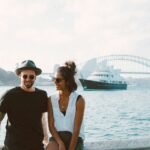 A happy couple enjoying a sunny day by Sydney Harbour with the iconic bridge in the background.