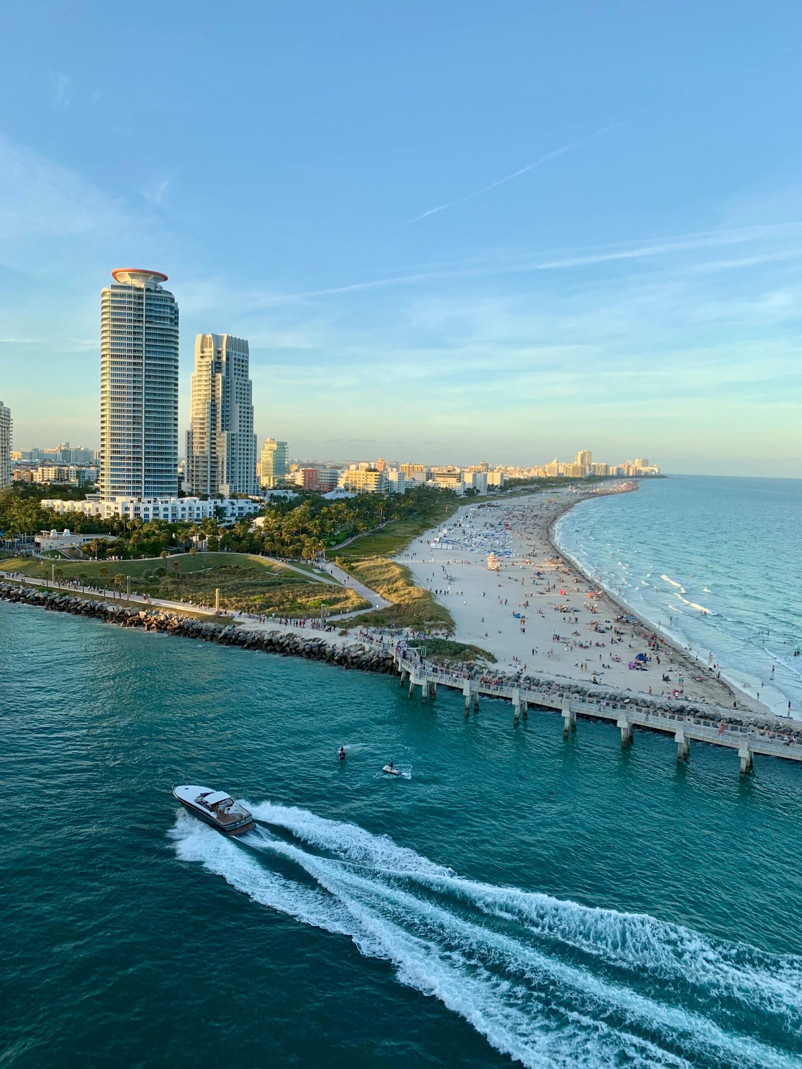 Stunning aerial shot of Miami Beach skyline, sandy beach, and vibrant ocean with passing boat.